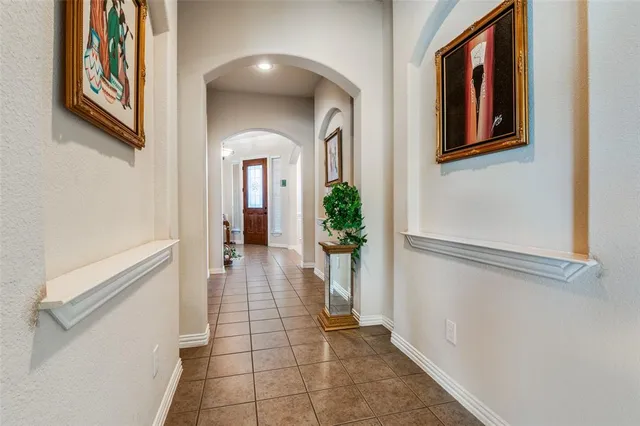 a view of a hallway with wooden floor and a living room