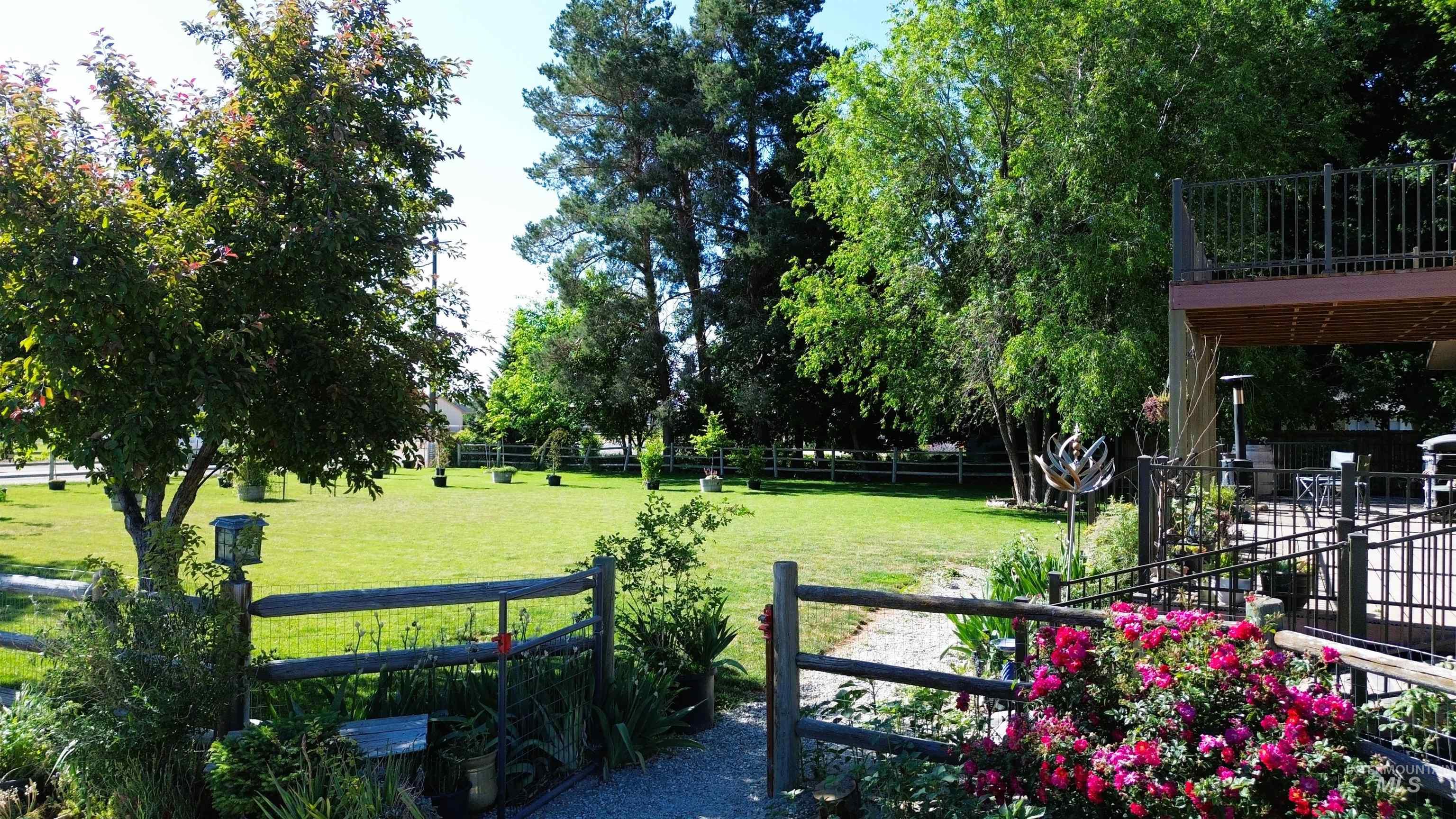 16985 Garnet Road Wilder, ID 83676 - Photo 5 of 39 Expansive green lawn with mature trees and a rustic wood fence