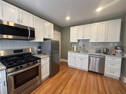 70 Strathmore Road, Unit 9B Boston, MA 02135 - Photo 1 of 19 a kitchen with stainless steel appliances white cabinets a stove a sink and a microwave