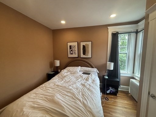 70 Strathmore Road, Unit 9B Boston, MA 02135 - Photo 15 of 19 a bedroom with a bed and wooden floor
