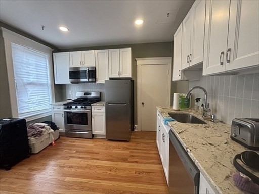 70 Strathmore Road, Unit 9B Boston, MA 02135 - Photo 3 of 19 a kitchen with granite countertop a sink stove and refrigerator