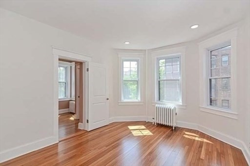 70 Strathmore Road, Unit 9B Boston, MA 02135 - Photo 9 of 19 an empty room with wooden floor and windows