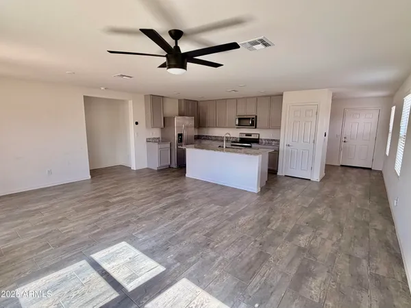 a view of a kitchen with a sink stove refrigerator and cabinets