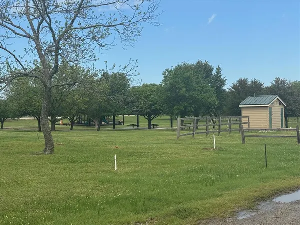 a grassy field with trees in the background