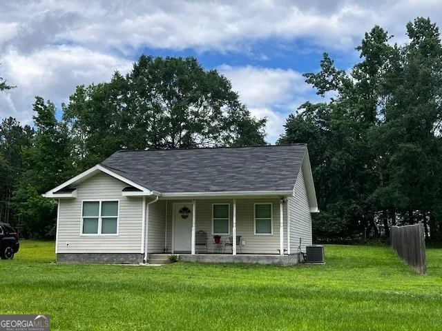 a front view of a house with a yard and trees