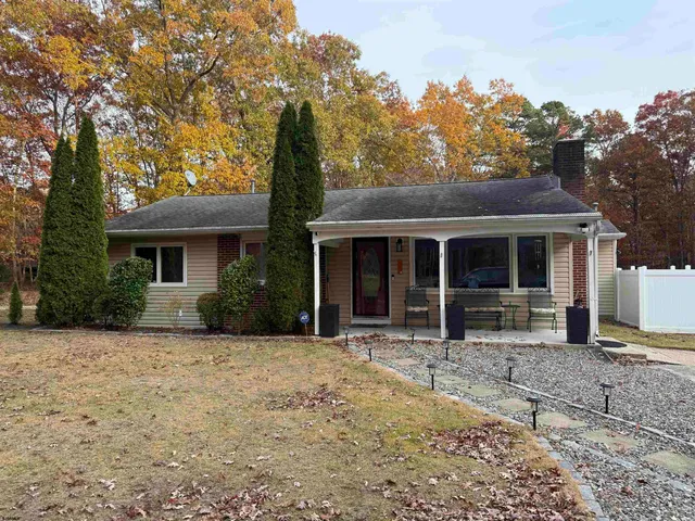 a front view of a house with a garden and trees
