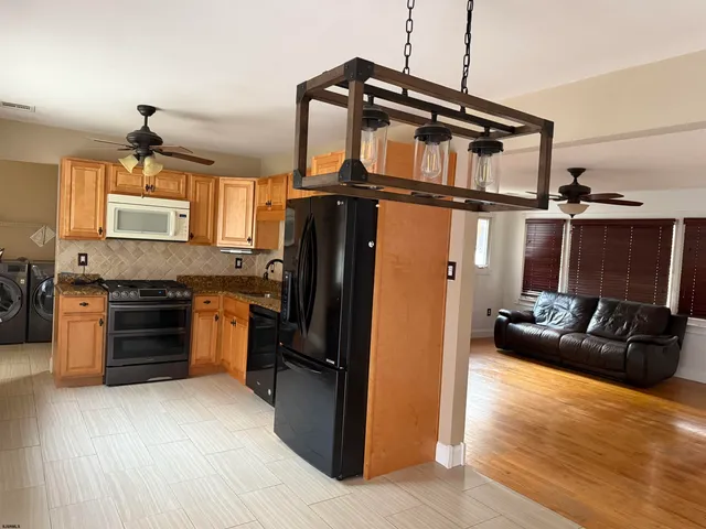 a kitchen with granite countertop a refrigerator stove and oven
