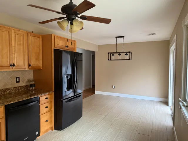 a kitchen with stainless steel appliances granite countertop a refrigerator and a stove top oven