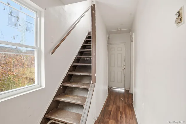 a view of a hallway with wooden floor and entryway