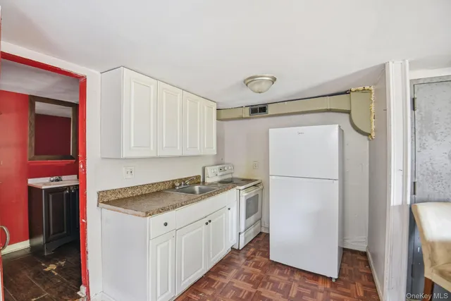 a kitchen with a refrigerator a stove and white cabinets