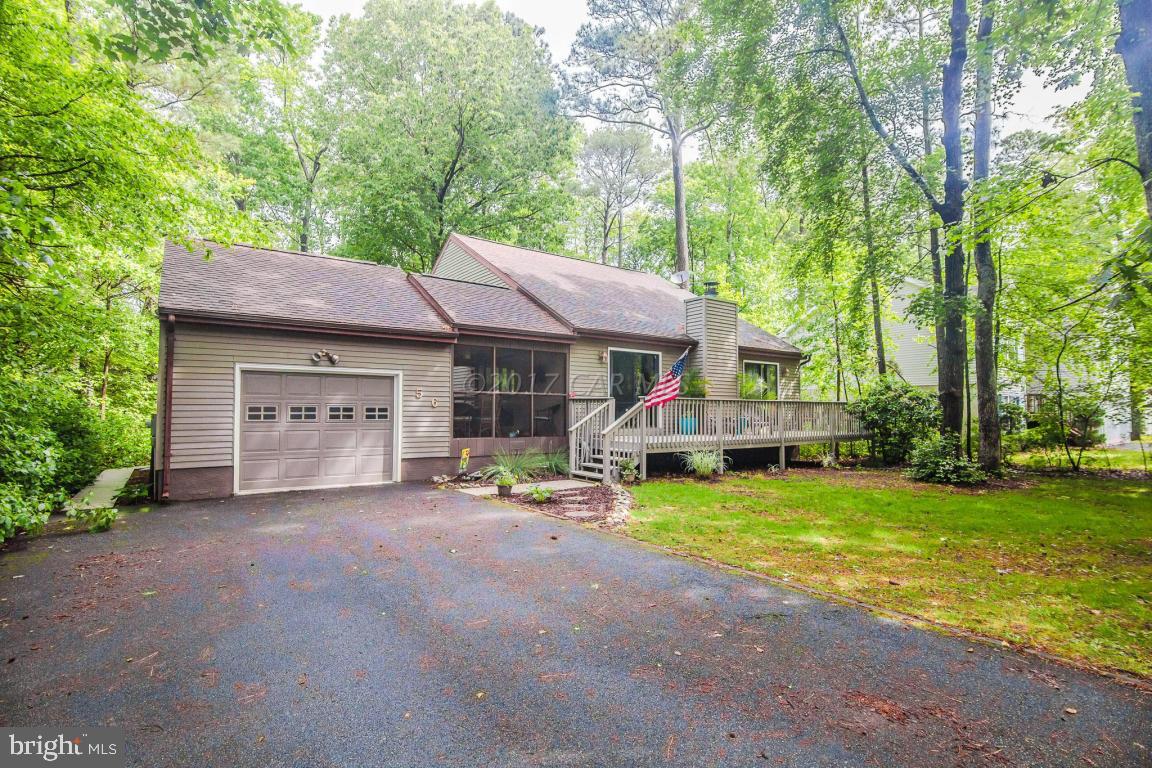 56 Pinehurst Road Ocean Pines, MD 21811 - Photo 1 of 42 a front view of a house with a yard and trees