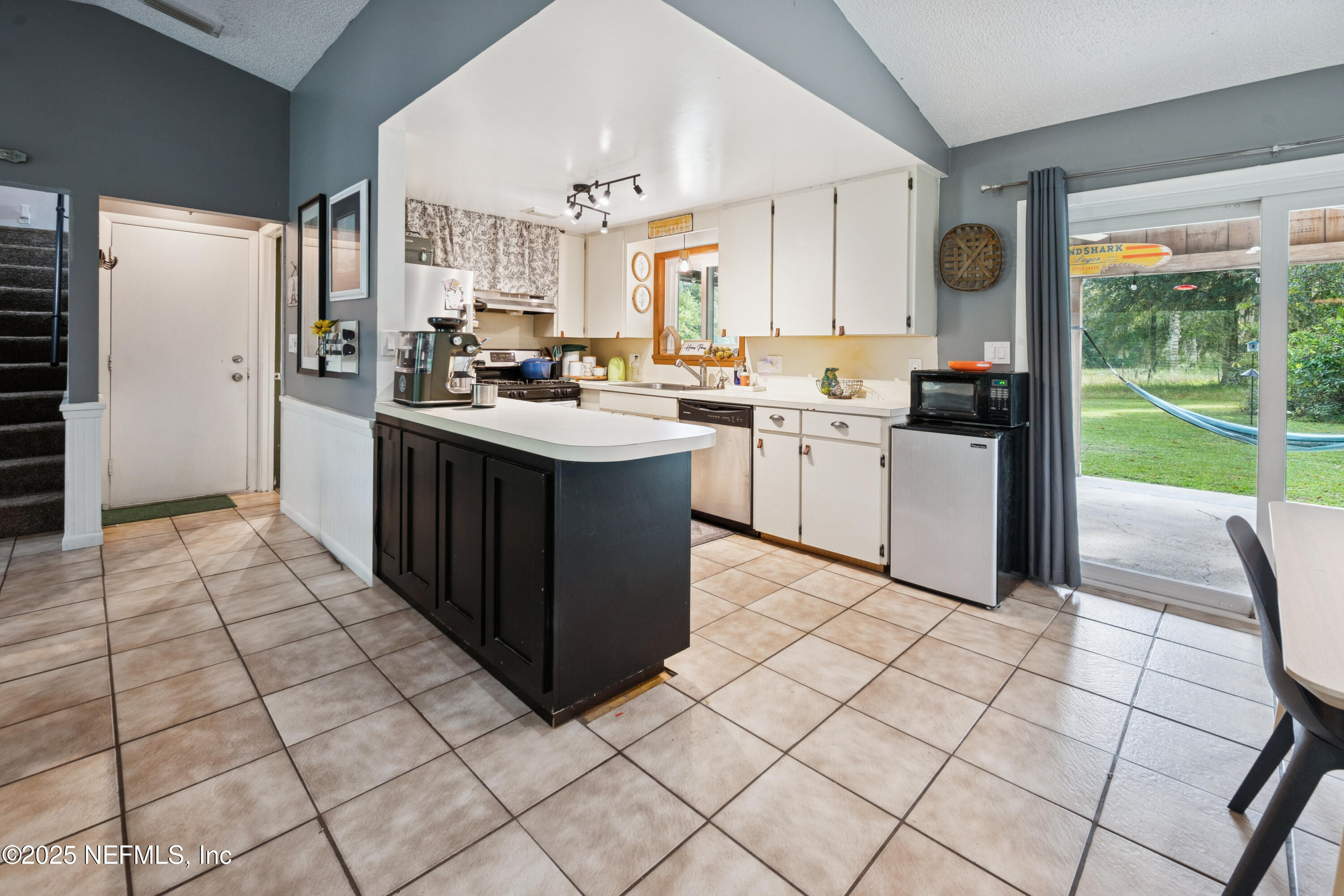 18311 Northeast 21 Street Gainesville, FL 32609 - Photo 22 of 80 a kitchen with a sink window and cabinets