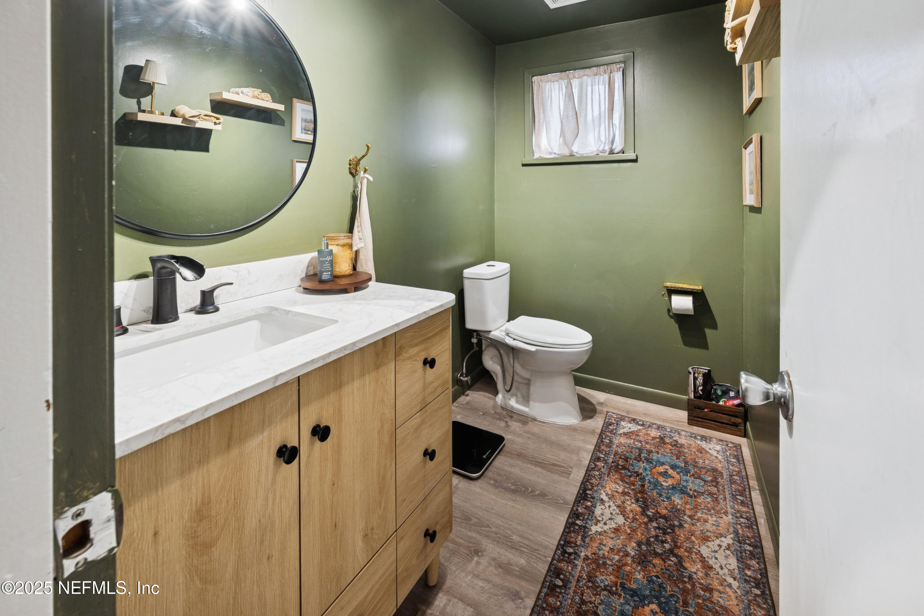 18311 Northeast 21 Street Gainesville, FL 32609 - Photo 29 of 80 a bathroom with a sink mirror and toilet