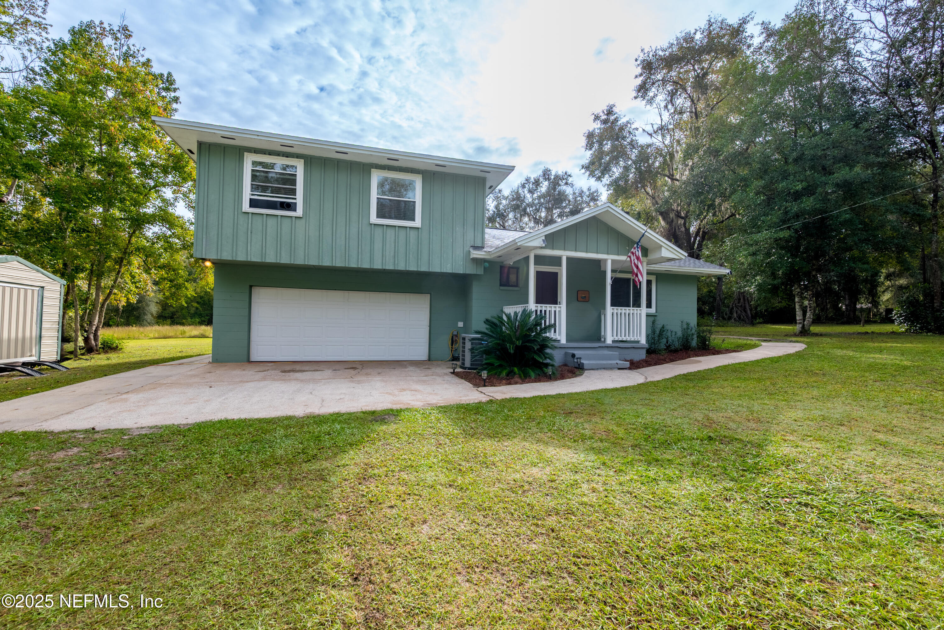 18311 Northeast 21 Street Gainesville, FL 32609 - Photo 5 of 80 a front view of a house with a yard and garage