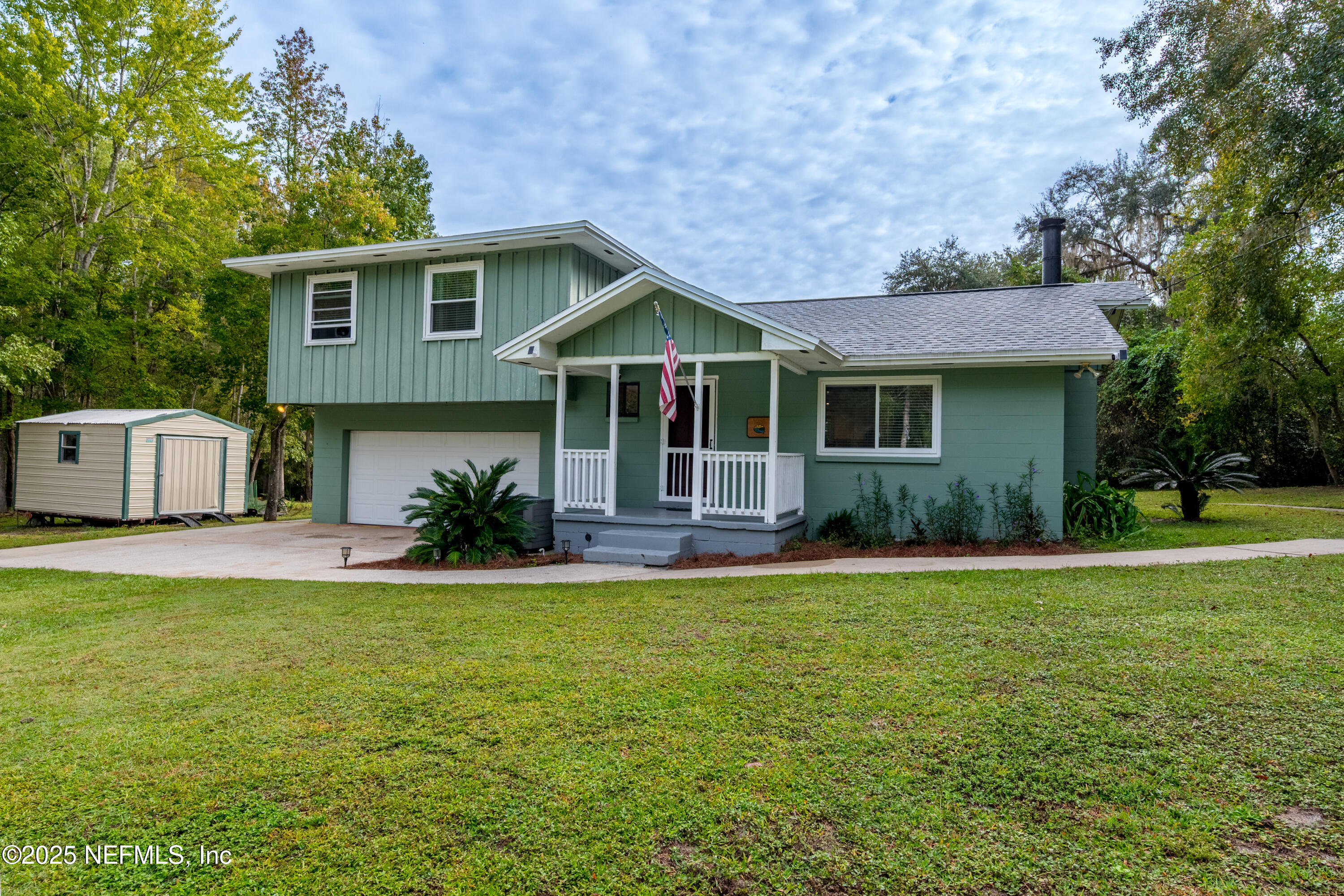 18311 Northeast 21 Street Gainesville, FL 32609 - Photo 7 of 80 a front view of a house with a garden and trees