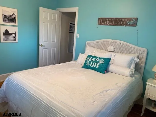 a bedroom with a bed and painting on the wall