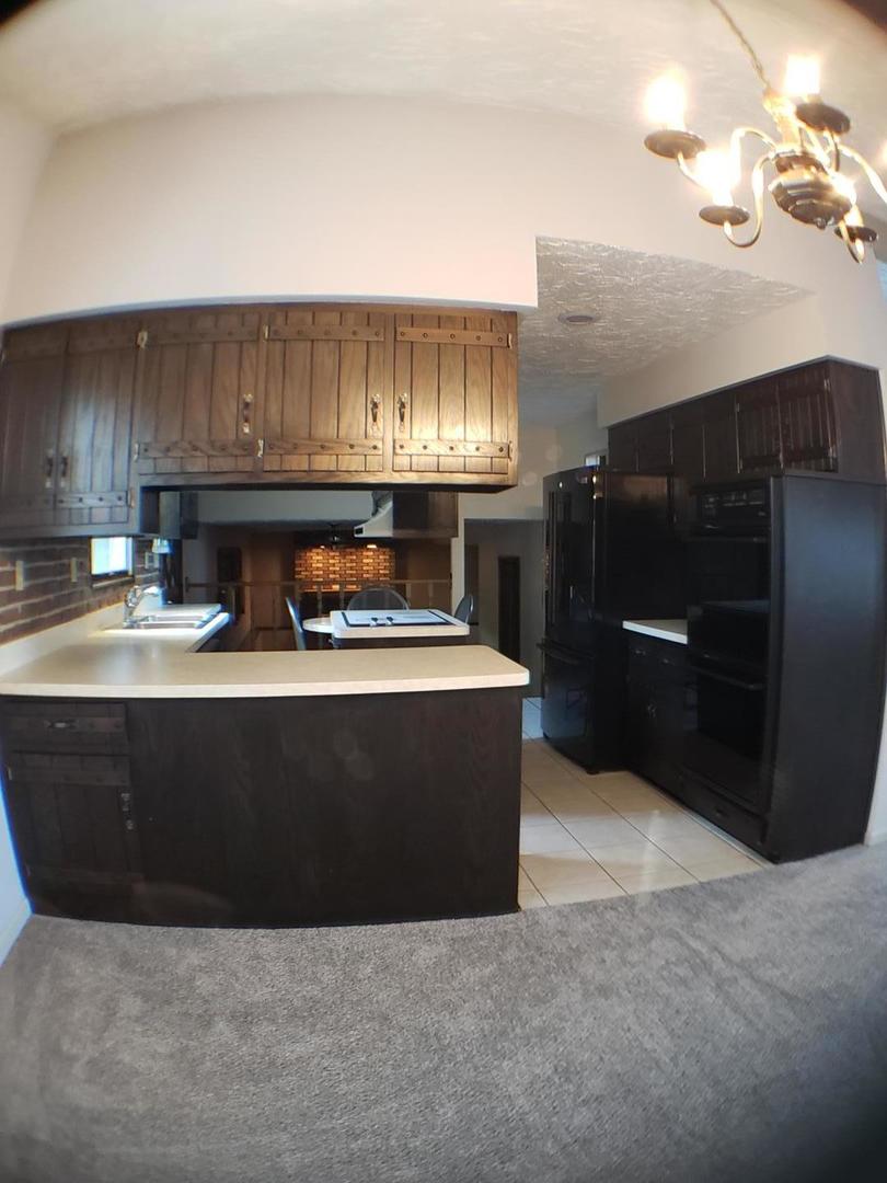 24805 Murphy Road Wilmington, IL 60481 - Photo 10 of 20 a living room with stainless steel appliances kitchen island granite countertop a refrigerator a stove and a sink with wooden cabinets