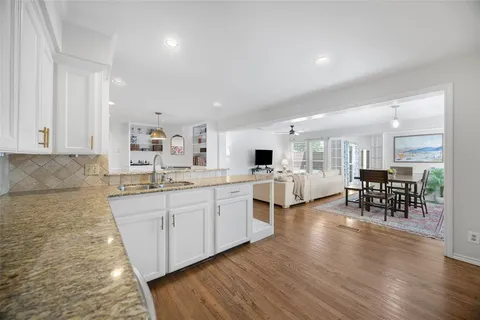 a large white kitchen with lots of counter space and furniture