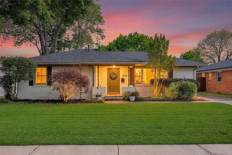a front view of a house with a garden and yard