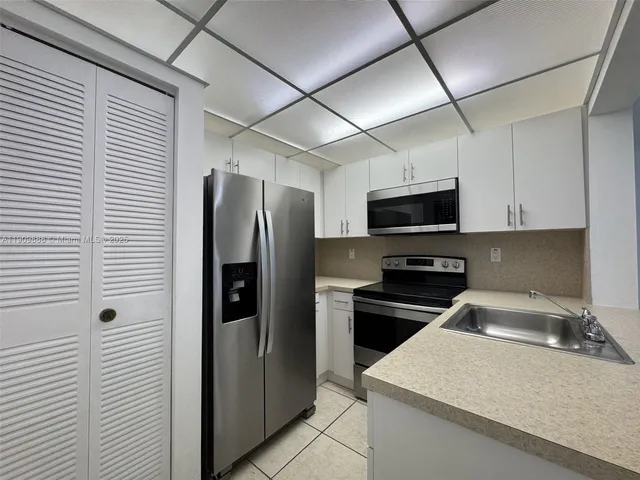 a kitchen with stainless steel appliances granite countertop a refrigerator a stove top oven a sink and dishwasher