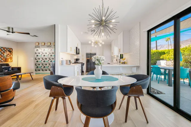 a living room with fireplace furniture and a kitchen view