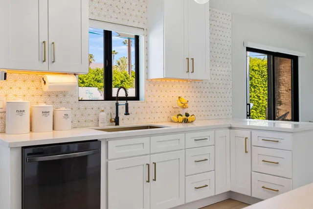 a kitchen with white cabinets and a window