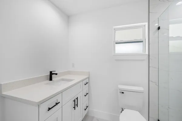 a bathroom with a sink a toilet and shower