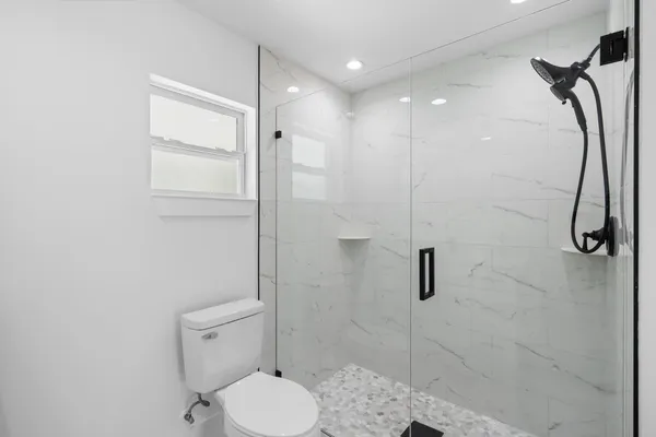 a bathroom with a toilet and a shower