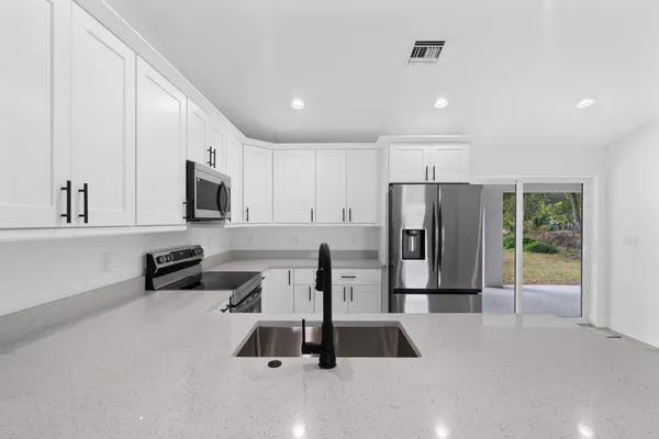 a kitchen with stainless steel appliances a refrigerator and microwave