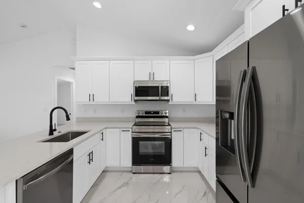 a kitchen with white cabinets and stainless steel appliances