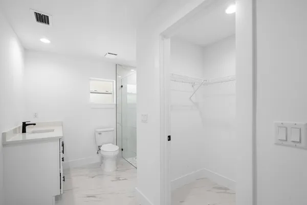 a bathroom with a sink a toilet and shower