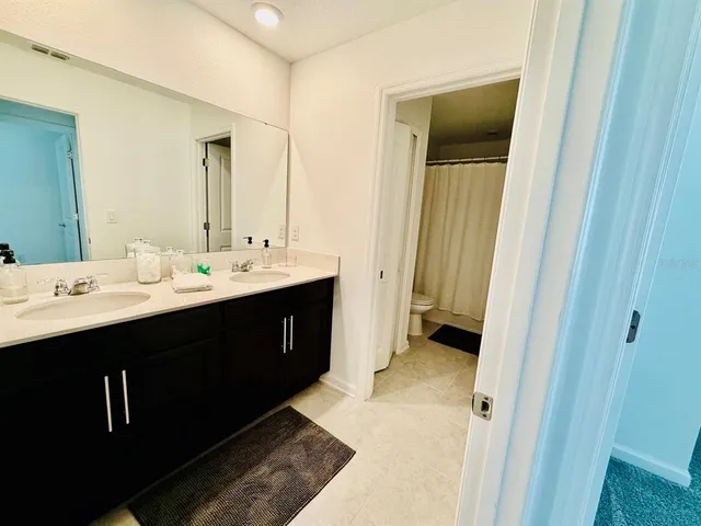a en suite bathroom with a double vanity sink and mirror