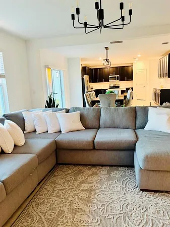 a living room with furniture and a chandelier