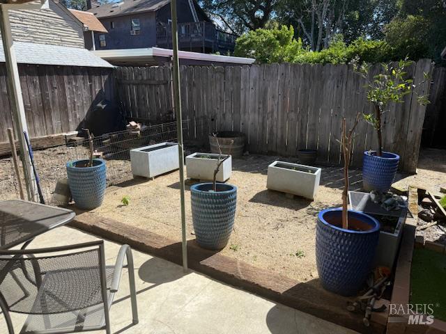 618 Benton Street Santa Rosa, CA 95404 - Photo 11 of 27 a view of a backyard with table and chairs potted plants and wooden fence