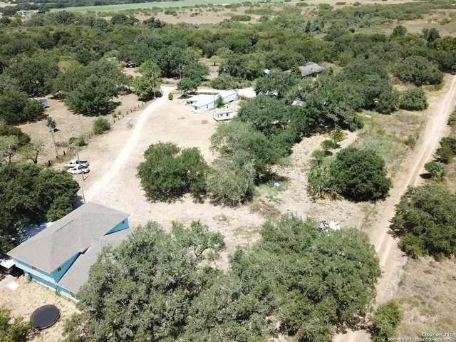 an aerial view of a house with a yard and large trees