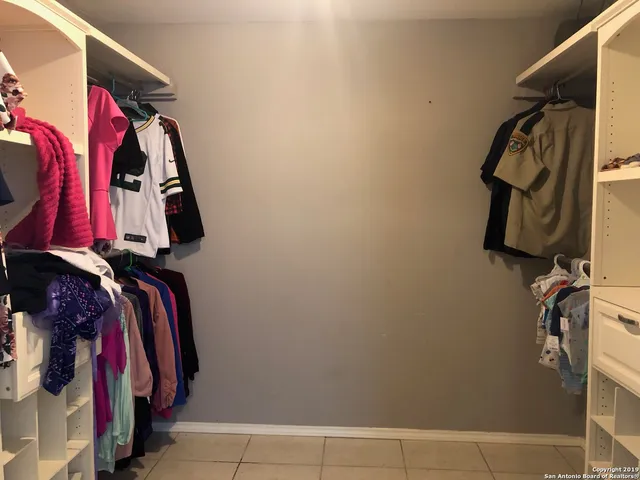 a view of walk in closet with clothes