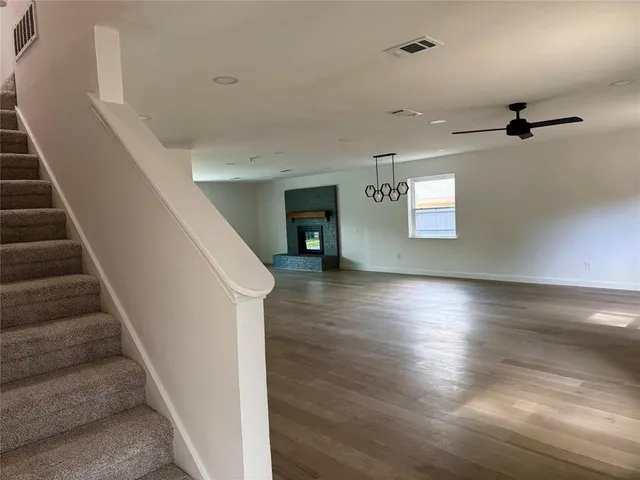 a view of a hallway with wooden floor and staircase