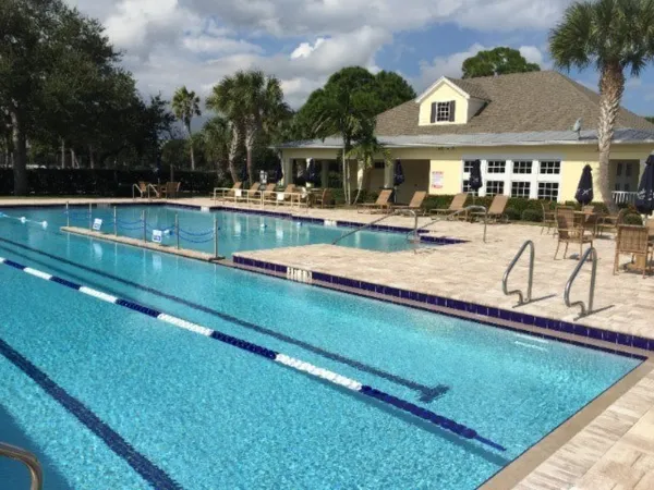 a view of an house with swimming pool and chairs
