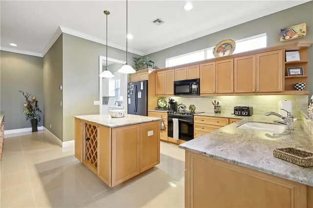 a kitchen with stainless steel appliances granite countertop a sink a stove and a refrigerator