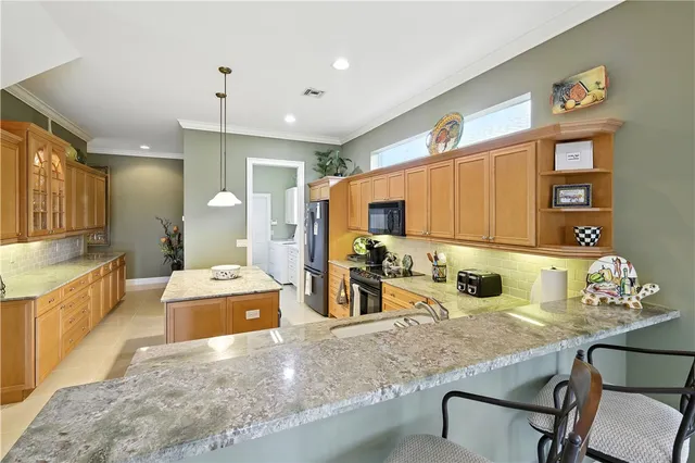 a kitchen with stainless steel appliances granite countertop a sink and a refrigerator