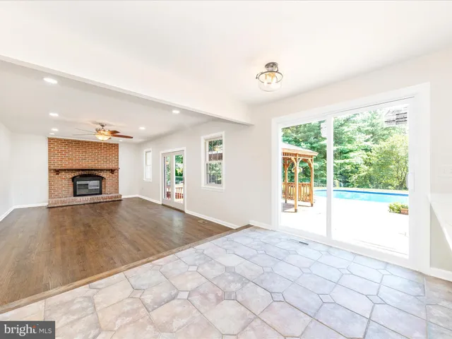 an empty room with windows and fireplace