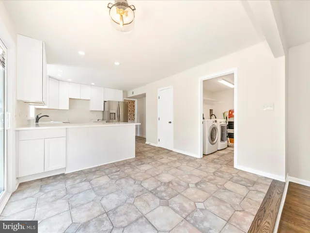an empty room with wooden floor a fireplace and windows