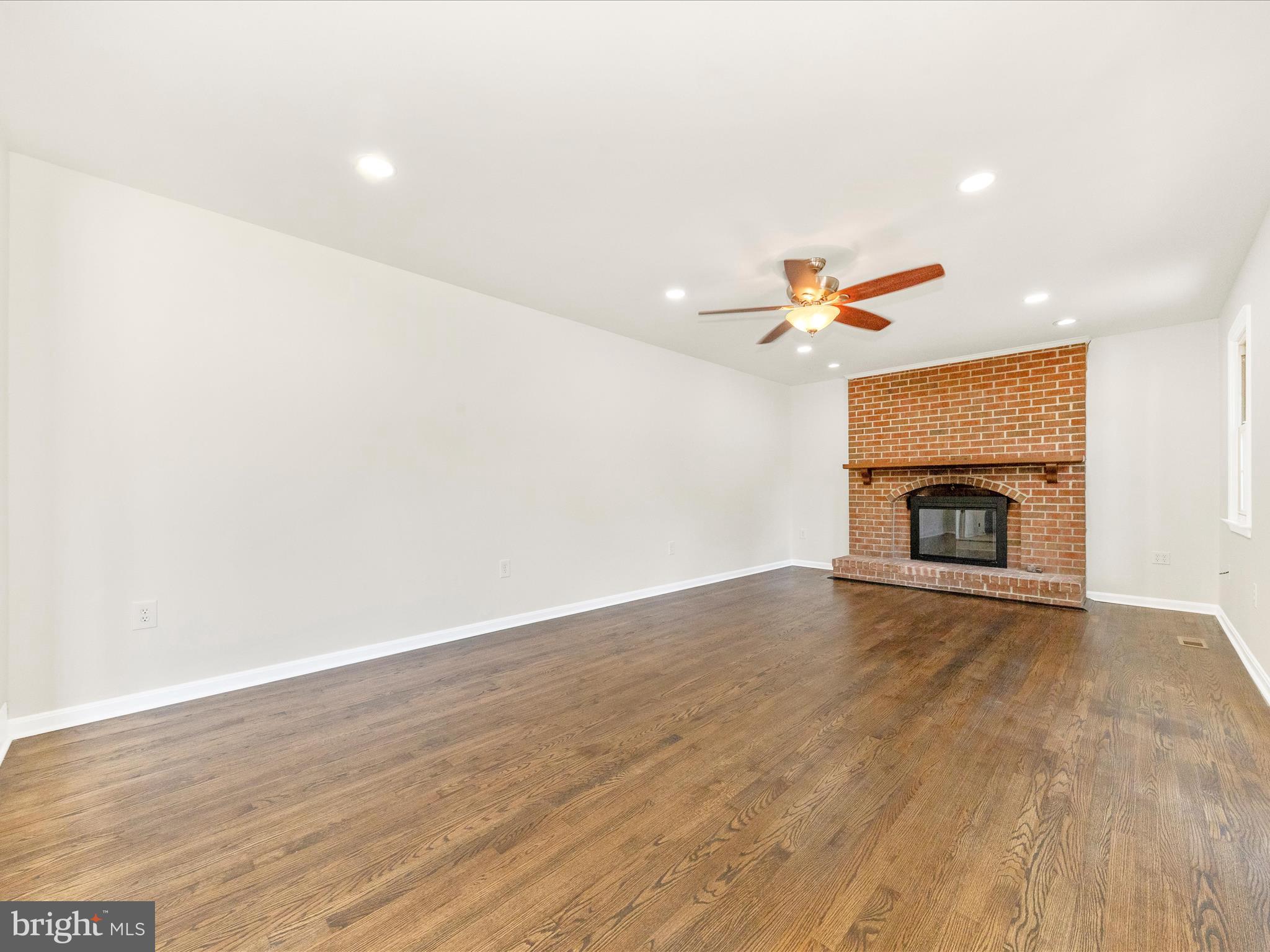 8395 Buckeye Court Frederick, MD 21702 - Photo 17 of 56 a view of empty room with wooden floor and fireplace