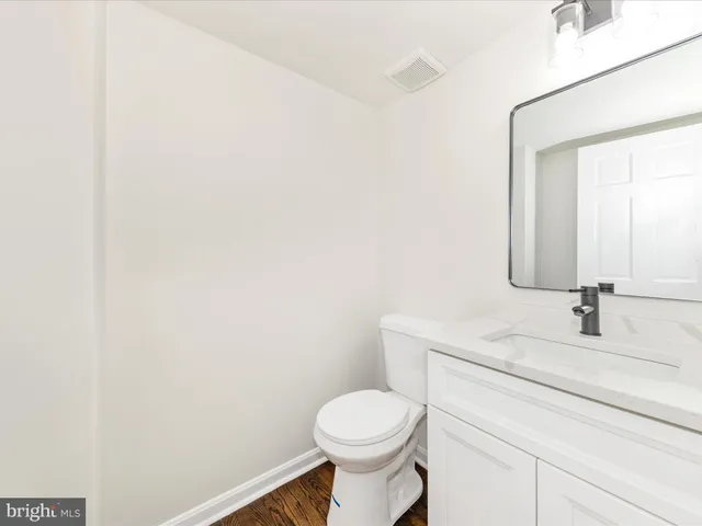 an empty room with wooden floor ceiling fan and windows