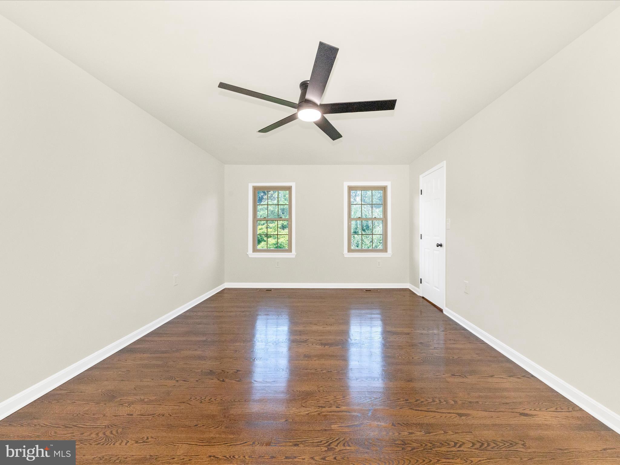 8395 Buckeye Court Frederick, MD 21702 - Photo 23 of 56 an empty room with wooden floor ceiling fan and windows