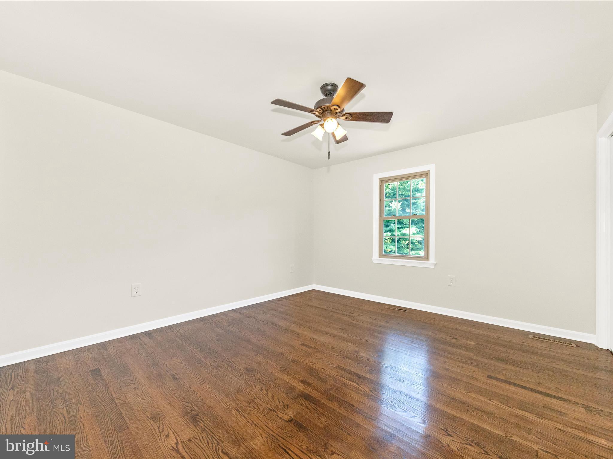8395 Buckeye Court Frederick, MD 21702 - Photo 28 of 56 an empty room with wooden floor and windows