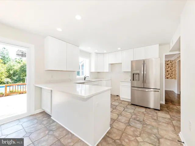 a kitchen with a sink a refrigerator and a stove top oven