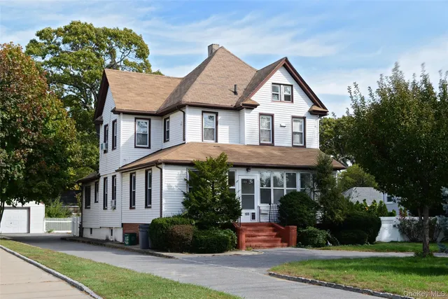 a front view of a house with a yard and potted plants