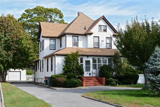 a front view of a house with a yard and trees