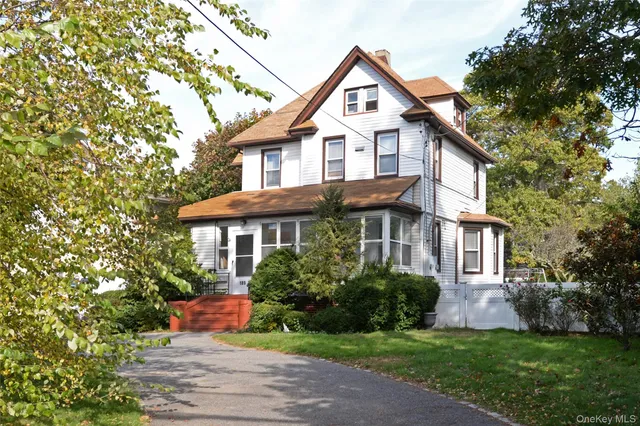 a front view of a house with a yard and trees